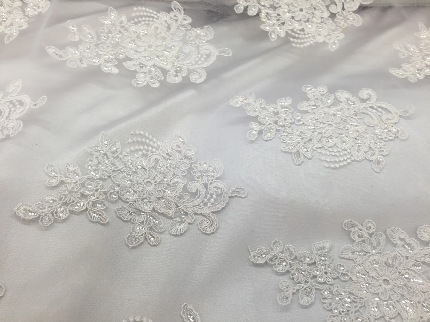 White flower lace corded and embroider with sequins on a mesh. Wedding/bridal/prom/nightgown fabric. Sold by the yard.